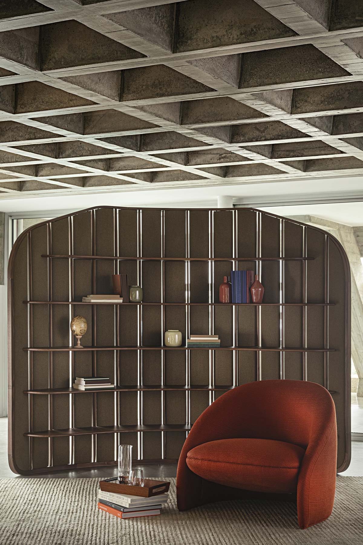 The Palm Armchair в ткани Poggio, оттенок Piment Doux; рядом — стеллаж Trama.